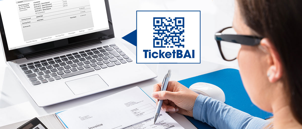 Mujer trabajando en ordenador portátil con logotipo TicketBai