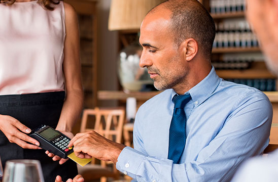 Ejecutivo pagando con tarjeta de crédito en un restaurante