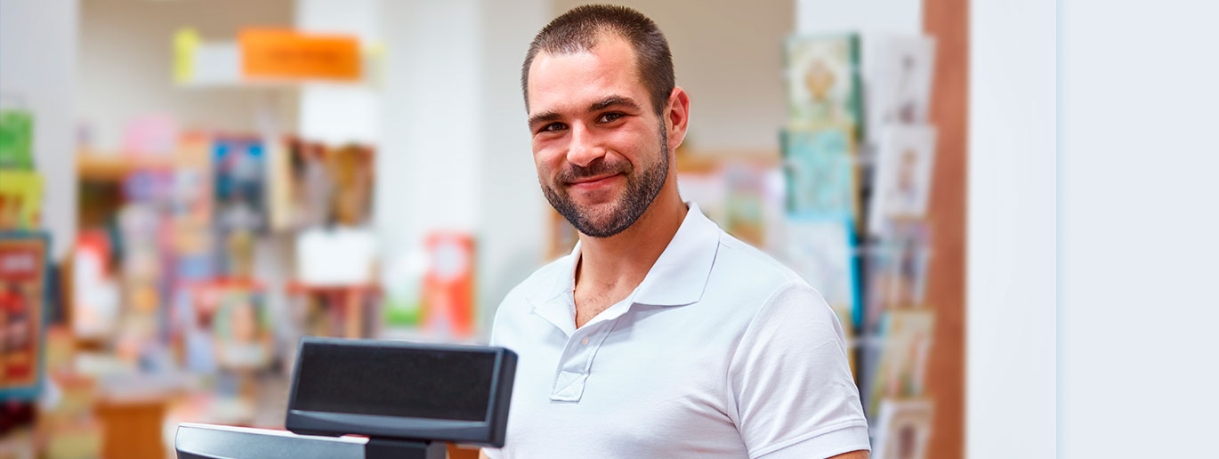 Hombre sonriente en tienda detrás de mostrador